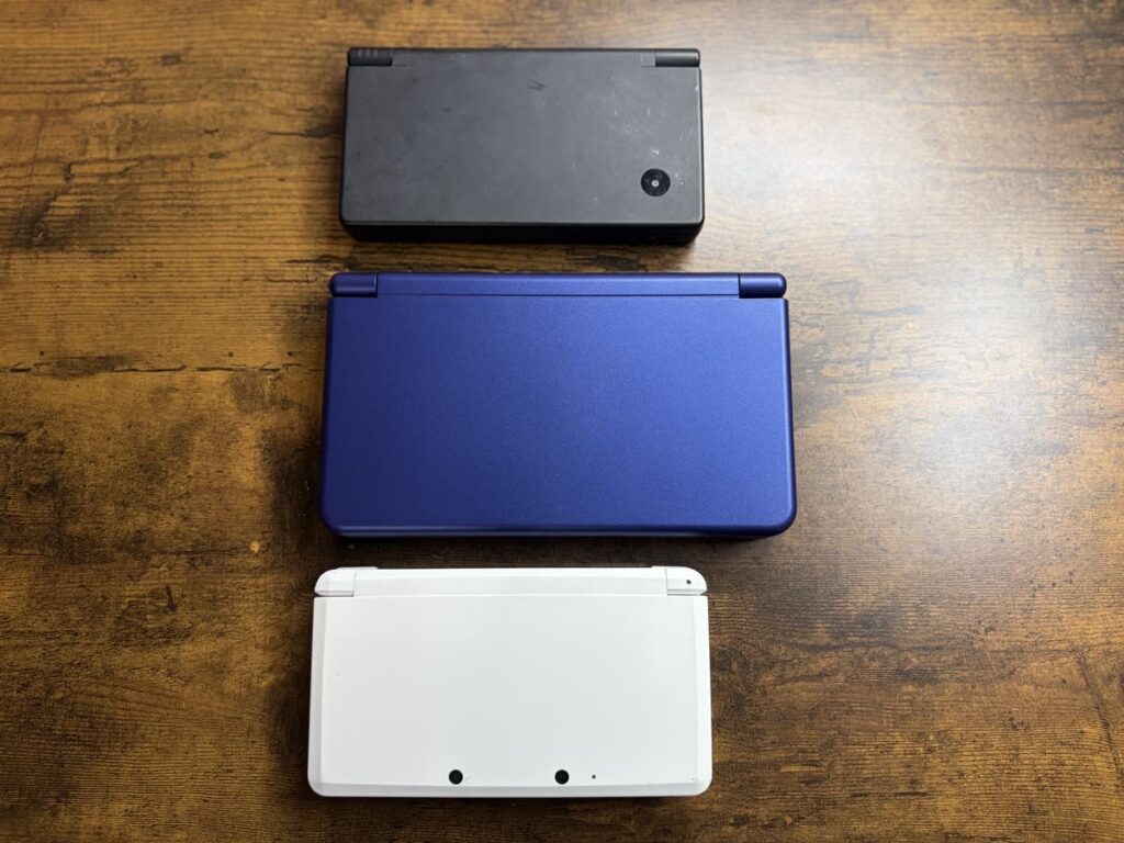 閉じた状態のニンテンドーDSi・RG DS Plus・3DS初期型を縦に並べて比較